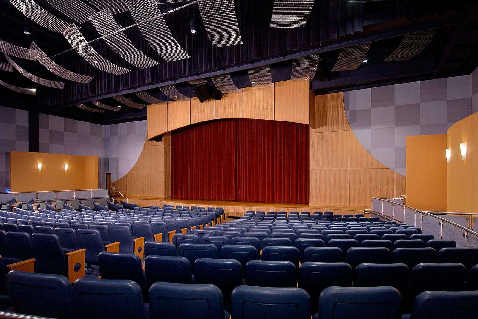 The 500-seat performing arts theatre with rows of blue seats facing a stage with a red curtain